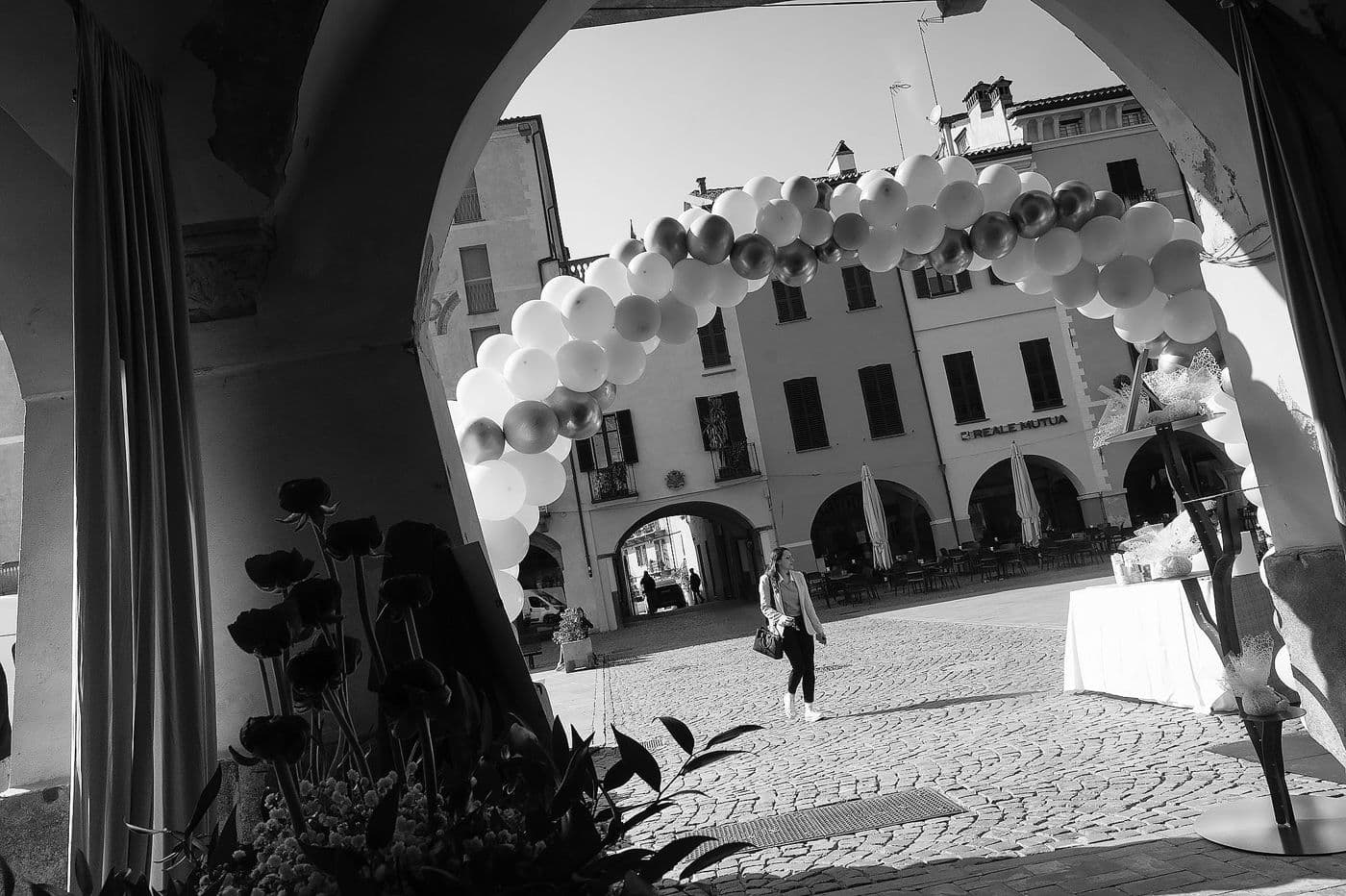 Arco di palloncini in piazza a Savigliano visto da sotto i portici